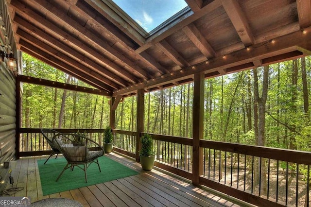 unfurnished sunroom with vaulted ceiling with skylight