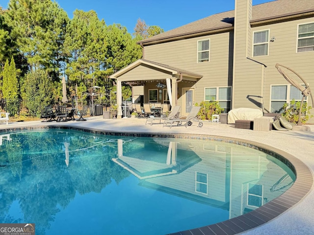 outdoor pool with fence and a patio