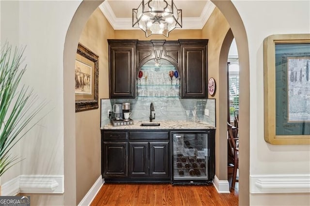 bar featuring dark hardwood / wood-style floors, sink, beverage cooler, decorative backsplash, and light stone counters