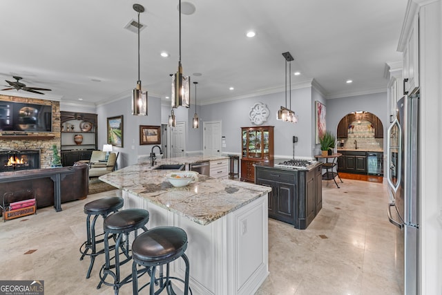 9135 Etching Overlook, Johns Creek, GA 30097 - kitchen with a spacious island, stainless steel appliances, a ceiling fan, recessed lighting, and a stone fireplace