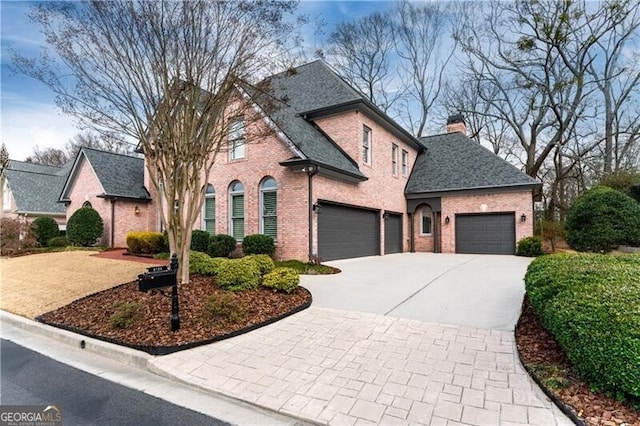 9135 Etching Overlook, Johns Creek, GA 30097 - french country style house featuring brick siding, driveway, a chimney, and a garage
