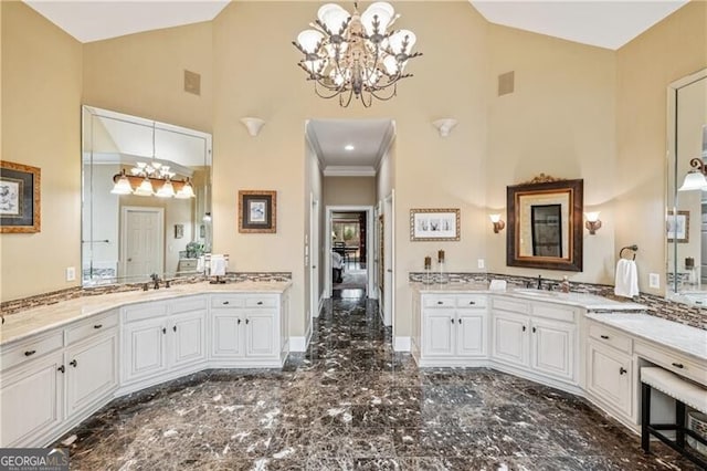 bathroom with vanity, a chandelier, and high vaulted ceiling