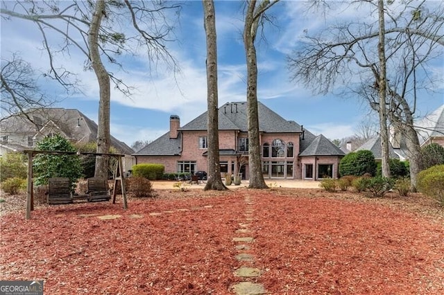 9135 Etching Overlook, Johns Creek, GA 30097 - rear view of house featuring a chimney and brick siding