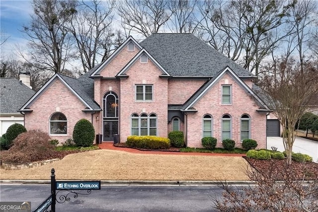 9135 Etching Overlook, Johns Creek, GA 30097 - traditional-style home with brick siding, concrete driveway, and roof with shingles