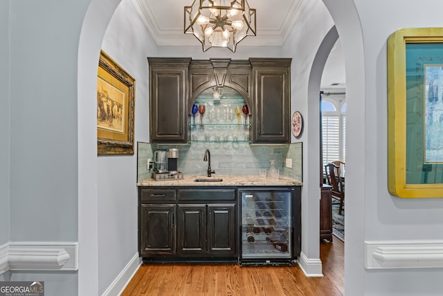 9135 Etching Overlook, Johns Creek, GA 30097 - indoor wet bar with beverage cooler, arched walkways, wood finished floors, tasteful backsplash, and crown molding