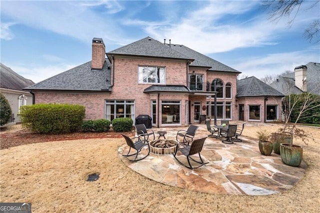 rear view of property with an outdoor fire pit and a patio