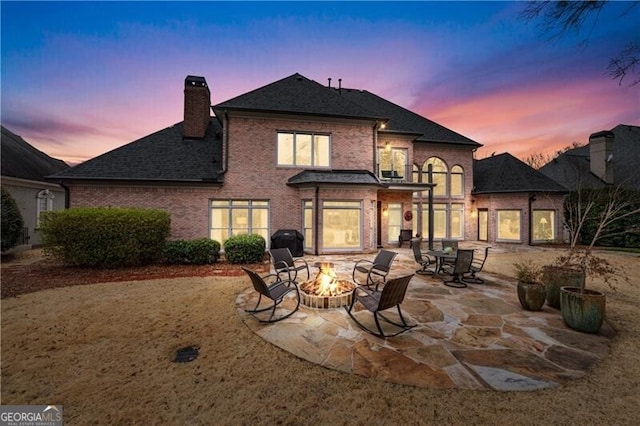 back house at dusk with a patio and a fire pit