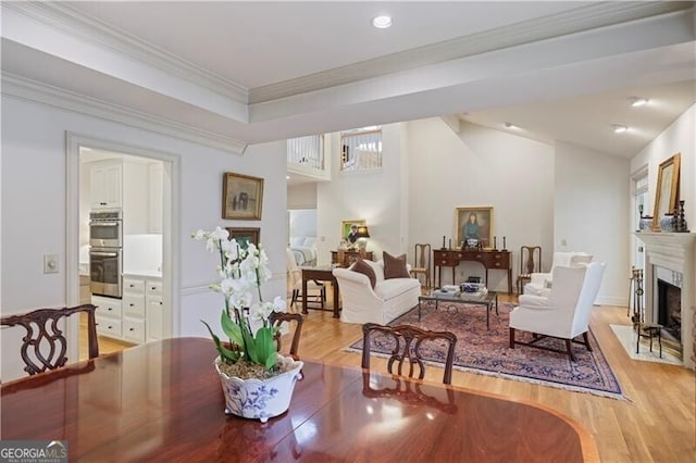 dining area featuring ornamental molding and light hardwood / wood-style flooring