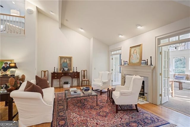 living room featuring wood-type flooring and high vaulted ceiling