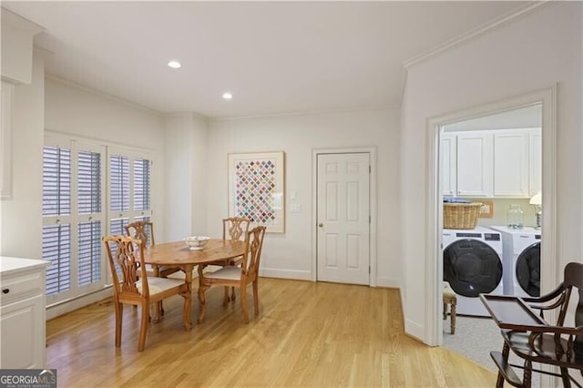 dining room featuring crown molding, washing machine and clothes dryer, and light wood-type flooring