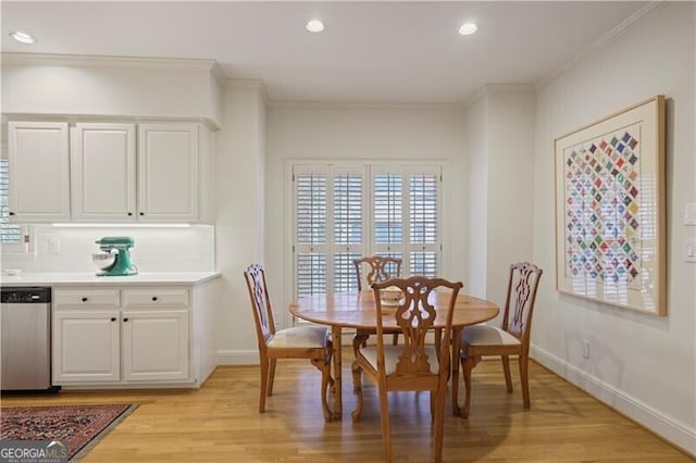 dining space with crown molding and light hardwood / wood-style floors