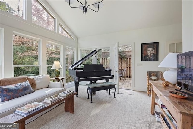 sitting room with light carpet, a notable chandelier, and high vaulted ceiling