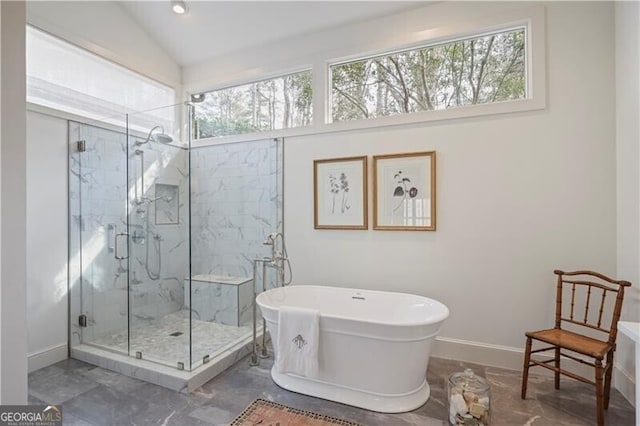 bathroom featuring a healthy amount of sunlight, plus walk in shower, and vaulted ceiling