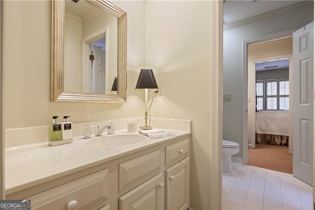 bathroom featuring vanity, crown molding, tile patterned floors, and toilet