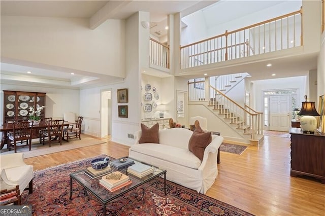 living room featuring a tray ceiling and light hardwood / wood-style flooring