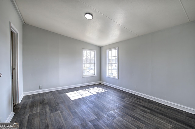 empty room with lofted ceiling and dark hardwood / wood-style floors