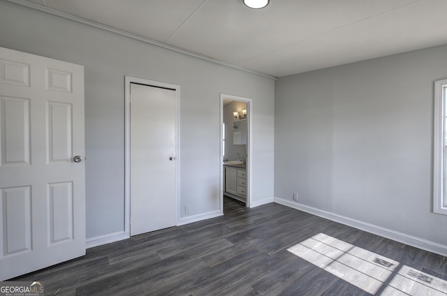 unfurnished bedroom with dark hardwood / wood-style flooring and ensuite bath