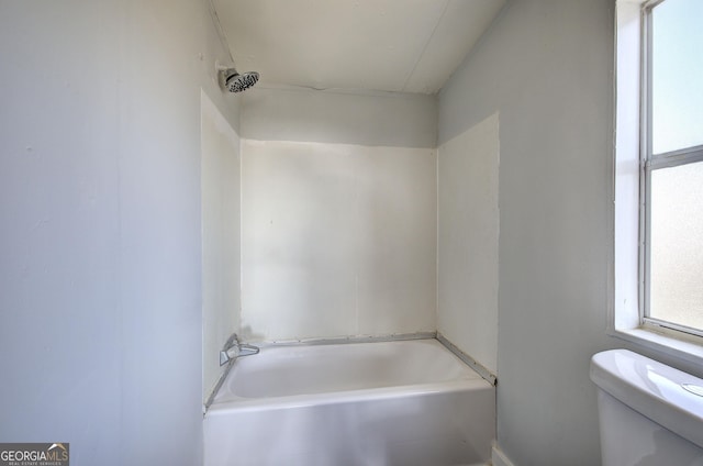 bathroom with a washtub and toilet