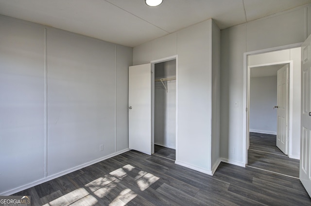 unfurnished bedroom with a closet and dark hardwood / wood-style floors