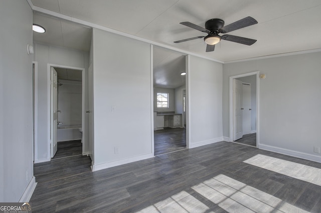 unfurnished bedroom featuring ceiling fan, dark hardwood / wood-style floors, a closet, and a spacious closet