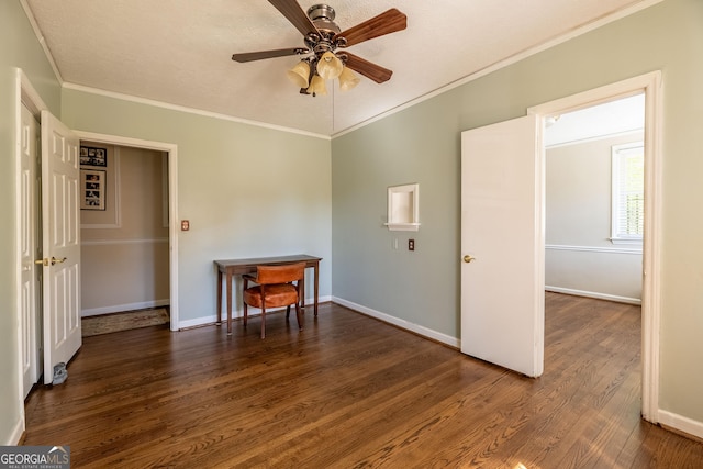 empty room featuring dark hardwood / wood-style flooring, crown molding, and ceiling fan