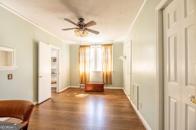 unfurnished room with ceiling fan, hardwood / wood-style flooring, ornamental molding, and a textured ceiling