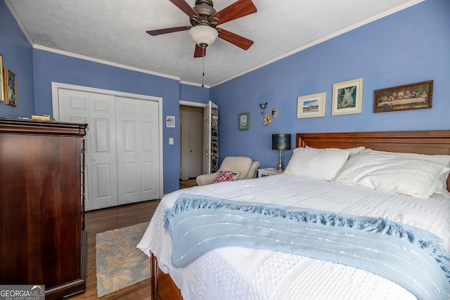 bedroom with crown molding, dark wood-type flooring, ceiling fan, and a closet