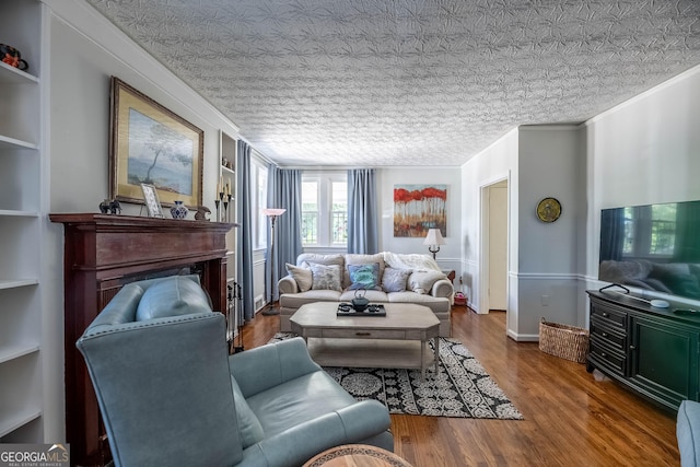 living room featuring crown molding, wood-type flooring, and built in features