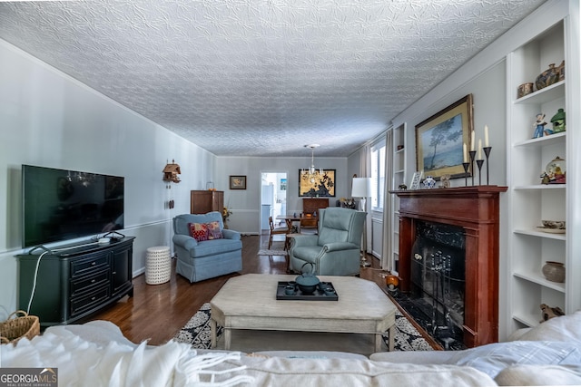 living room featuring a premium fireplace, built in shelves, dark hardwood / wood-style floors, and a textured ceiling