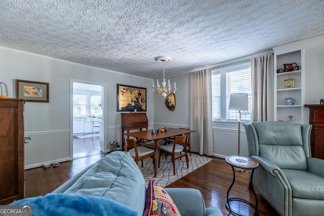 interior space featuring an inviting chandelier, ornamental molding, dark hardwood / wood-style flooring, and a textured ceiling