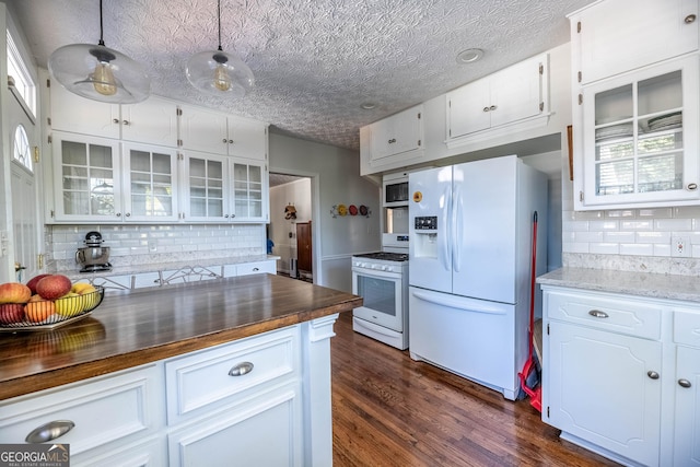 kitchen with butcher block counters, hanging light fixtures, white appliances, and white cabinets