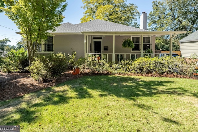 rear view of property featuring a lawn