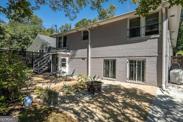 rear view of house featuring a patio area and a fire pit