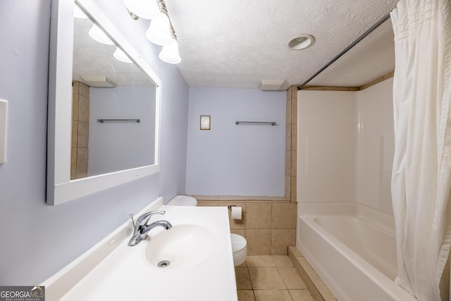 full bathroom featuring sink, tile walls, tile patterned flooring, toilet, and a textured ceiling