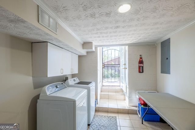 washroom featuring light tile patterned flooring, washer and dryer, a textured ceiling, ornamental molding, and electric panel