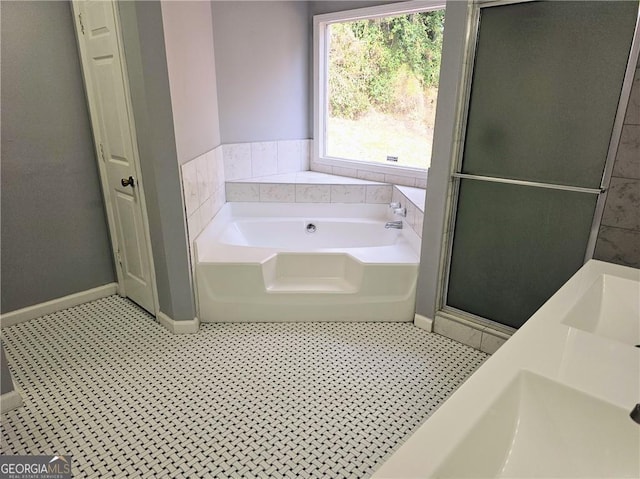 bathroom featuring plus walk in shower and dual sinks