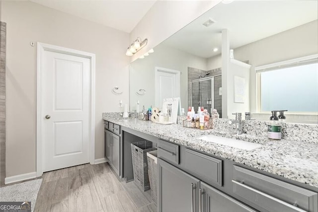 bathroom with vanity, wood-type flooring, and a shower with shower door