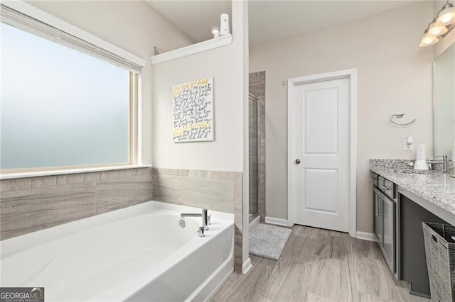 bathroom featuring vanity, hardwood / wood-style flooring, and shower with separate bathtub