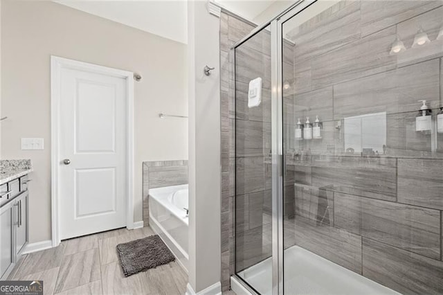 bathroom with independent shower and bath and vanity