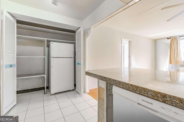 kitchen featuring ceiling fan, white appliances, stone counters, and light tile patterned floors