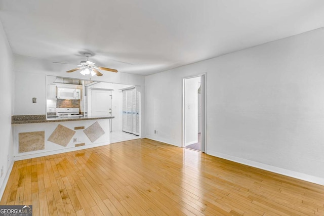 unfurnished living room with ceiling fan and light hardwood / wood-style floors