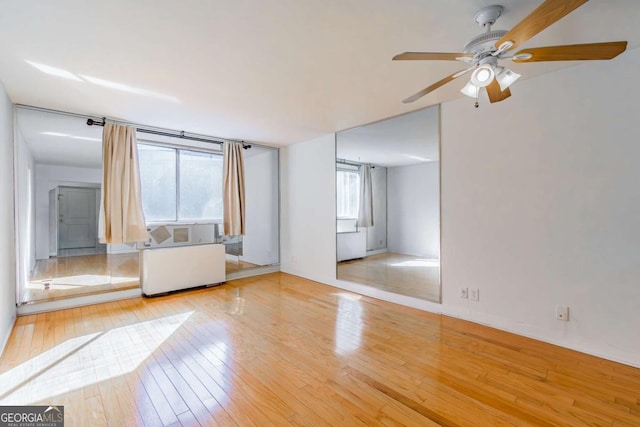 unfurnished living room with ceiling fan and light wood-type flooring