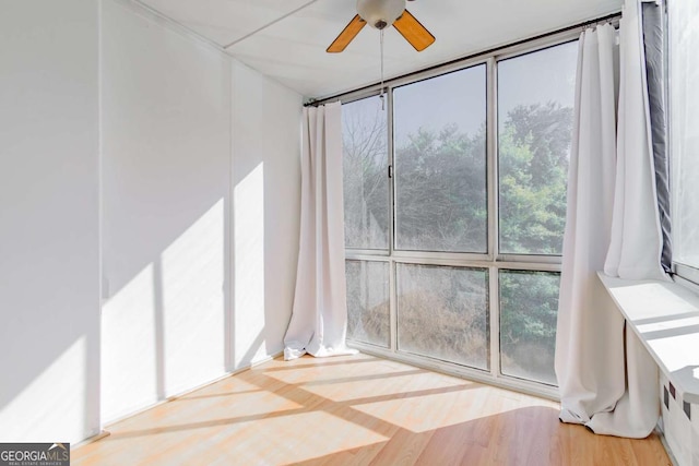 unfurnished sunroom with ceiling fan