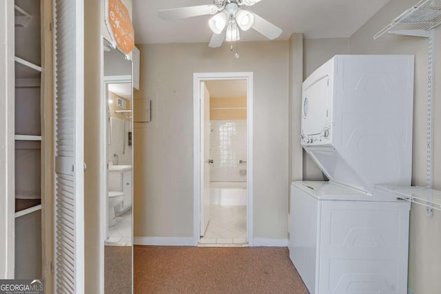 laundry room with ceiling fan, stacked washer and dryer, and carpet