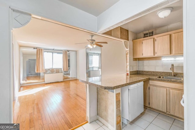 kitchen with sink, white dishwasher, kitchen peninsula, ceiling fan, and light hardwood / wood-style floors