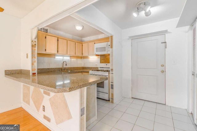 kitchen featuring sink, white appliances, decorative backsplash, kitchen peninsula, and light brown cabinets