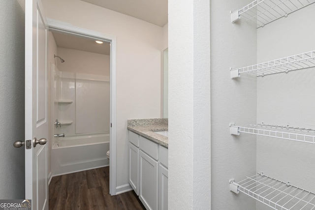 full bathroom with vanity, shower / washtub combination, hardwood / wood-style floors, and toilet