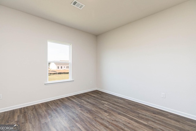 unfurnished room with dark hardwood / wood-style flooring