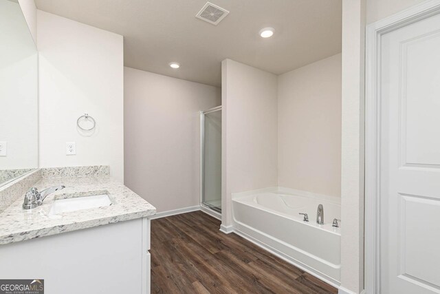 bathroom featuring independent shower and bath, wood-type flooring, and vanity