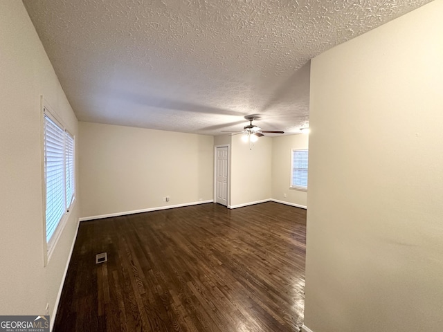 unfurnished room featuring dark wood-type flooring, ceiling fan, and a textured ceiling